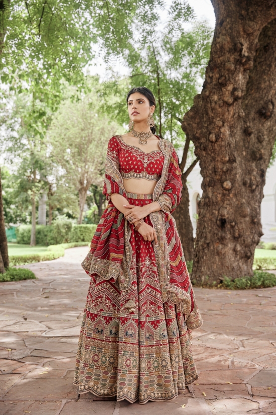 CREAM IVORY BANARASI LEHENGA SET AND A MIRROR EMBROIDERED CONTRAST RED  BLOUSE PAIRED WITH A MULTI COLOURED EMBROIDERED PATCHWORK DUPATTA AND LIGHT  GOLD EMBELLISHMENTS. - Seasons India